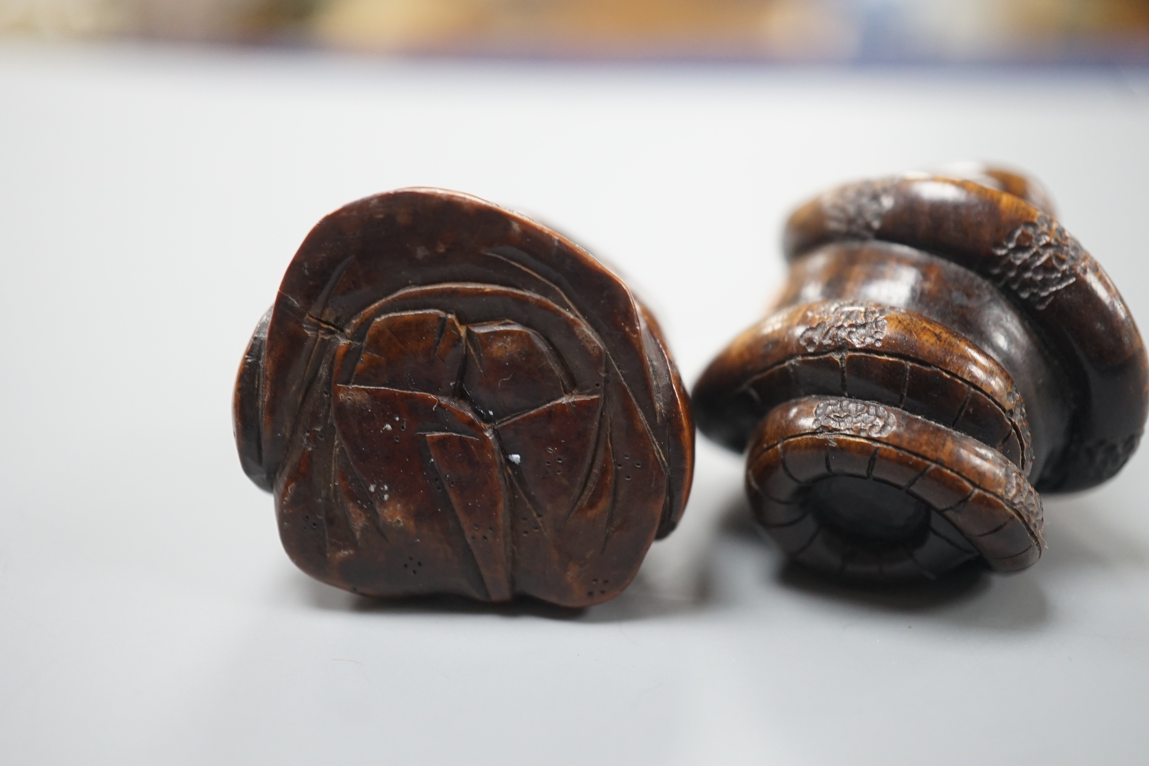 A Continental wood ‘chick and egg’ brooch ivory, 5.3cm, a Japanese ivory and wood figure and a wood netsuke of snakes (3)